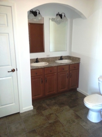 Double sinks, linen closet in master bath.